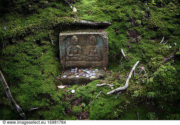 Münzen im Steinschrein im japanischen Zen-Tempelgarten