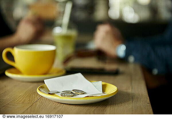 Münzen und Geldschein auf Cafétisch