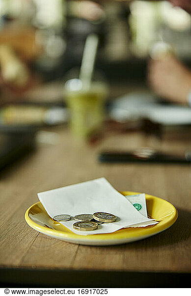 Münzen und Rechnung auf Restauranttisch