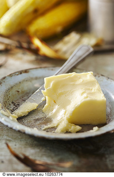 Mais Zuckermais Kukuruz gebraucht Messer Hintergrund Maiskolben Stück Butter Metall
