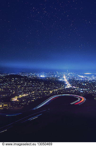 Majestätischer Anblick von Lichtspuren auf kurvenreicher Straße gegen ein Sternenfeld