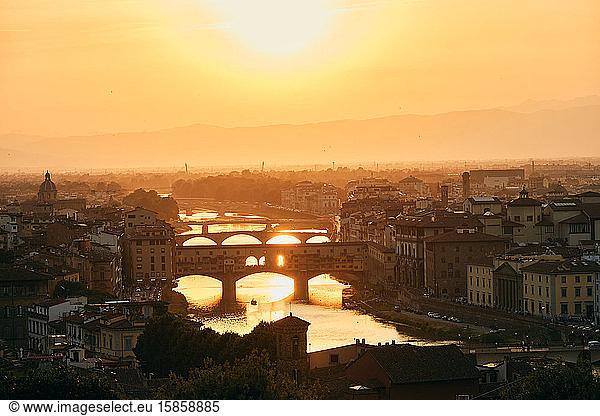 Majestic cityscape with bridges over river in golden sunshine