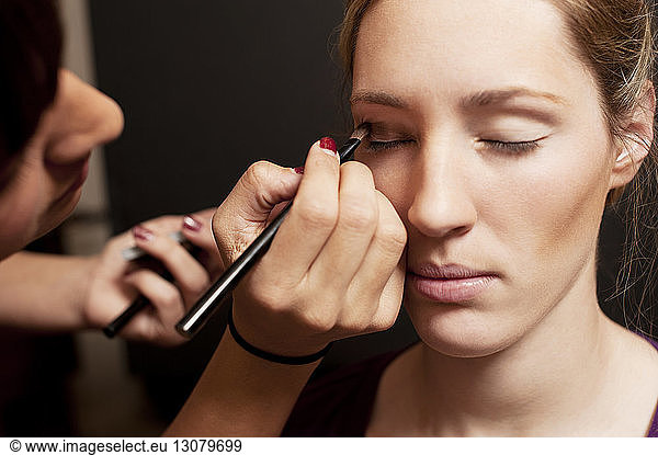 Make-up artist applying eye shadow on fashion model