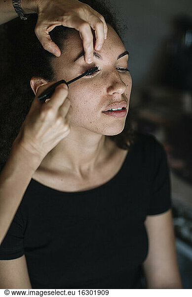 Make-up artist applying mascara on bride eye