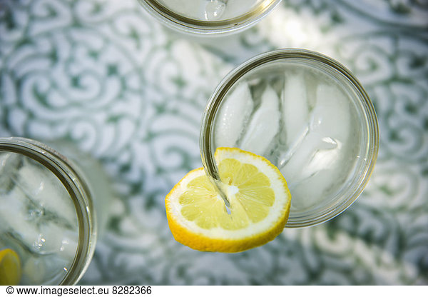 Making Lemonade. Overhead Shot Of Lemonade Glasses With A Fresh Slice Of Lemon In The Edge Of The Glass. Organic Lemonade Drinks.