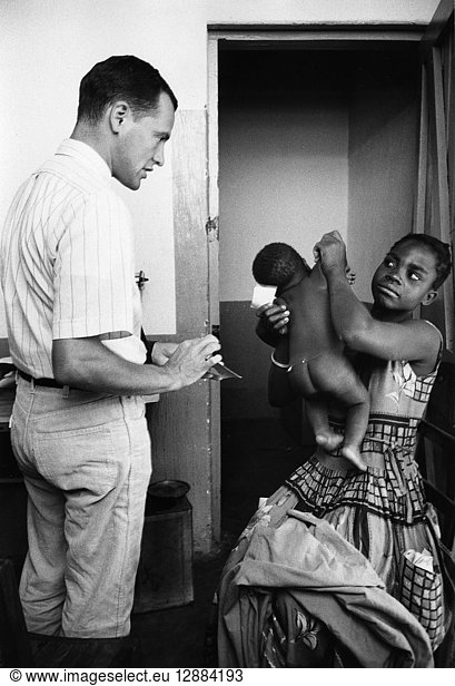 MALAWI: PUBLIC HEALTH  c1965. Peace Corps volunteer Jack Allison with a mother and baby in a clinic in Nsiyaludsu  Malawi. Photograph  c1965.