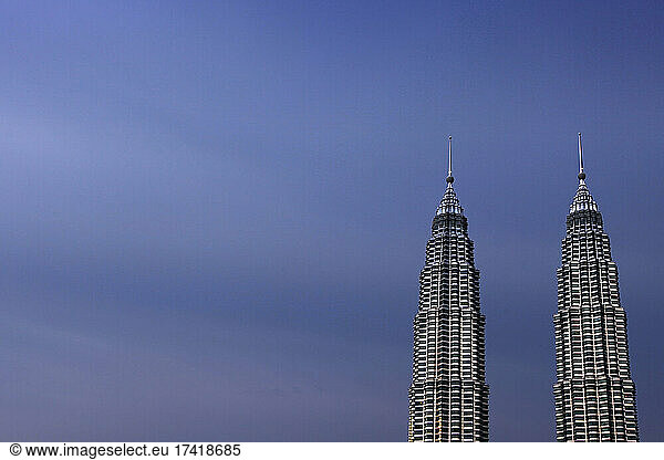 Malaysia  Kuala Lumpur  Petronas Towers standing against sky at dusk