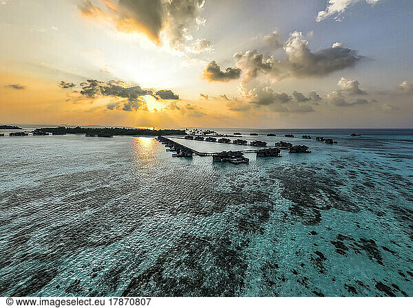 Maldives  North Male Atoll  Lankanfushi  Aerial view of Indian Ocean at sunset with tourist resort bungalows in background