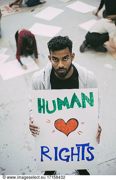 Male activist holding human rights poster during social issues