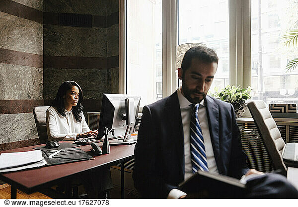 Male and female financial advisors working at law office