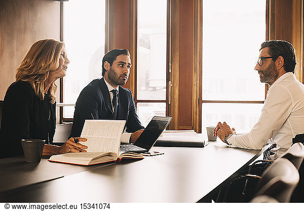 Male and female lawyers discussing with businessman in meeting at office