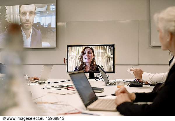 Male and female professionals planning strategy in web conference meeting at workplace