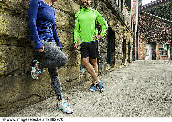 Male and female runners talking while resting during jogging  Seattle  Washington State  USA