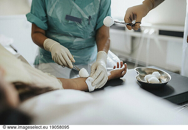 Male and female surgeons operating woman in hospital