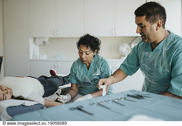 Male and female surgeons operating young patient in hospital