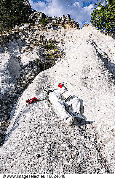 Male astronaut lying on mountain