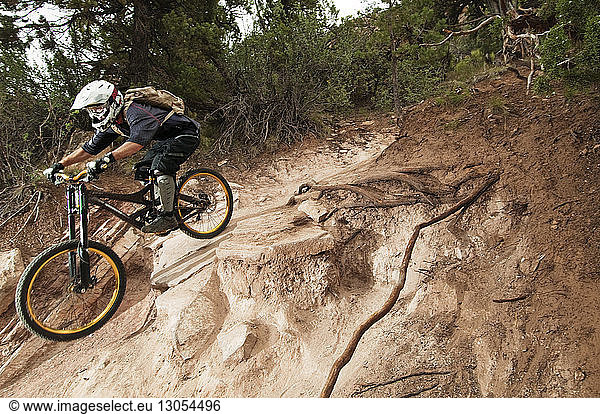 Male athlete cycling on rocks