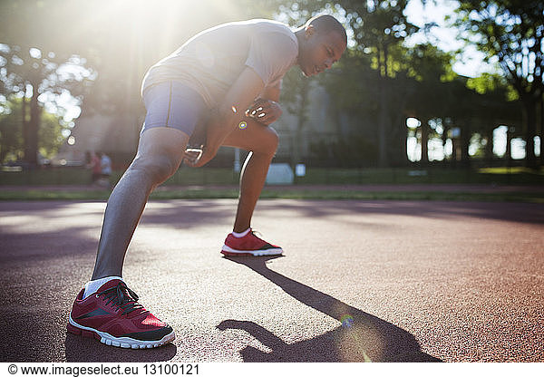Male athlete exercising in park on sunny day