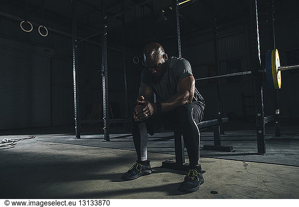 Male athlete relaxing in gym
