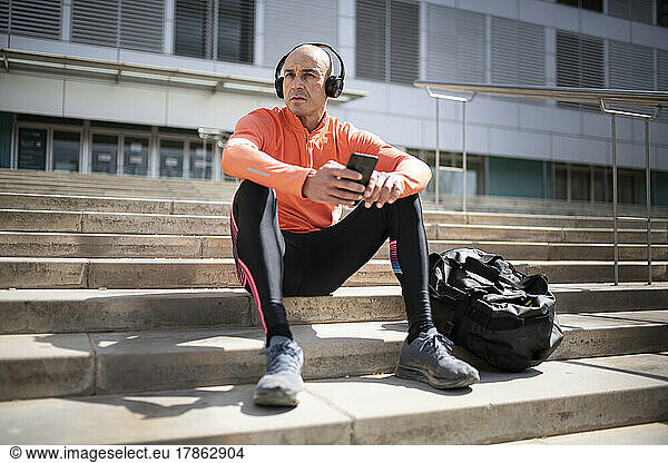 male athlete sitting and resting after street workout session