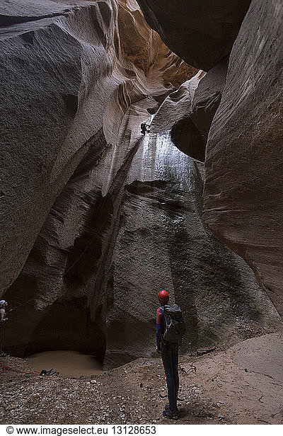 Male backpacker standing amidst rock formation