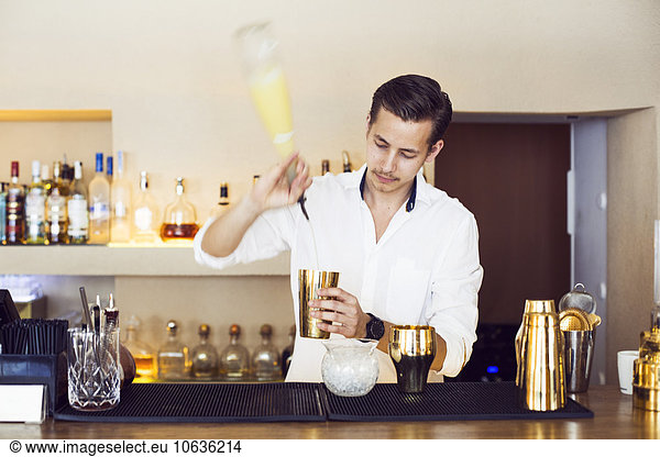 Male bartender making drink at counter in Lebanese restaurant
