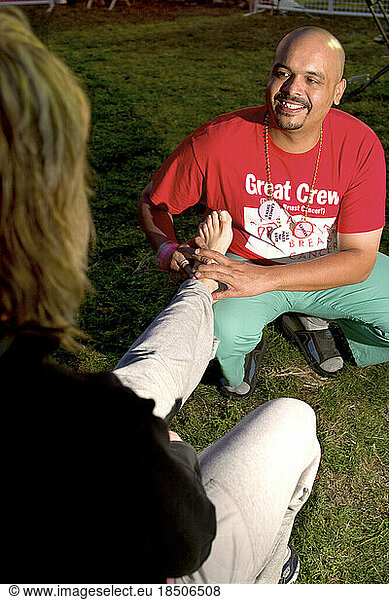 Male breast cancer survivor gives another walker a foot massage during the Avon Walk for Breast Cancer in NYC.