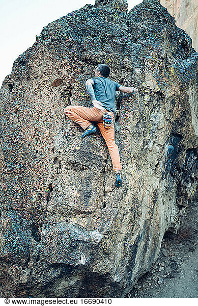 Male climber getting ready for a push to the boulder top in Smith Rock
