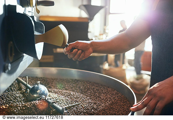 Male coffee roaster roasting coffee beans