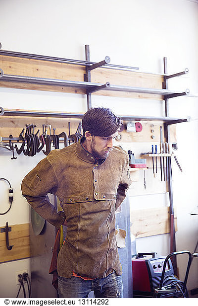 Male craftsperson wearing protective workwear at wood shop