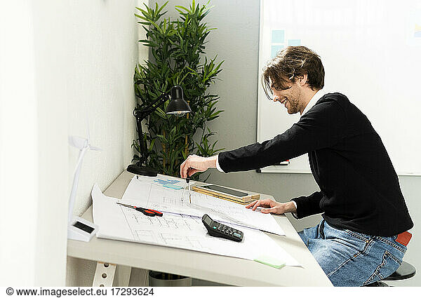 Male design professional making business plan on paper at office