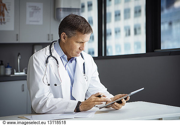Male doctor using tablet computer in clinic