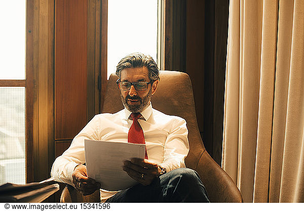 Male financial advisor reading documents at legal office
