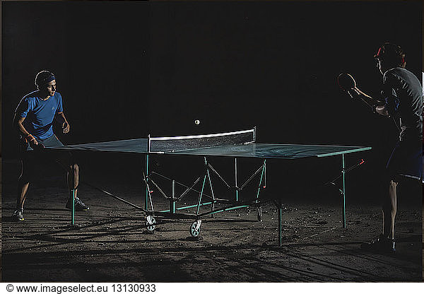 Male friends playing table tennis