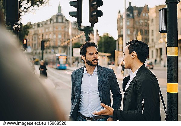 Male friends talking during city exploration