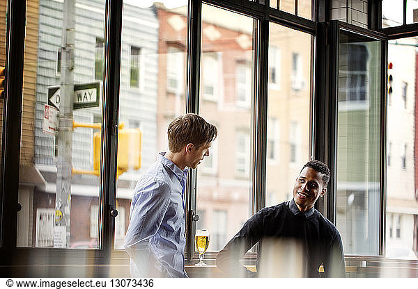 Male friends talking in bar