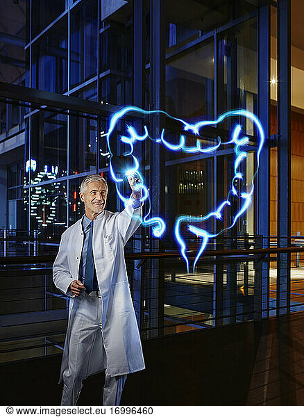 Male gastroenterologist examining large intestine with light painting at hospital