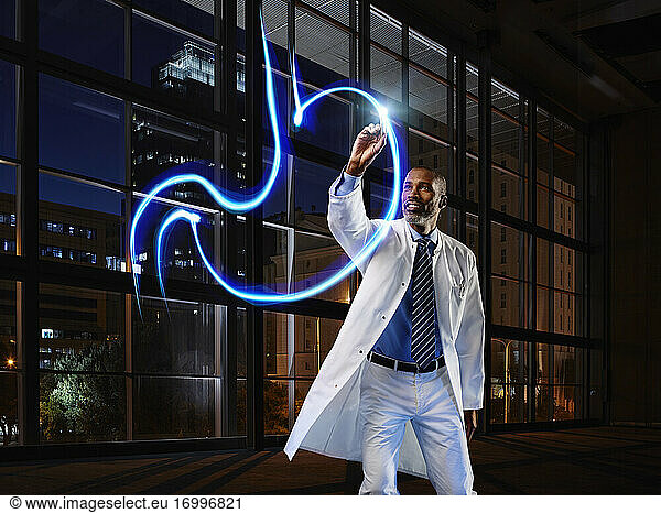 Male gastroenterologist light painting stomach in laboratory at hospital