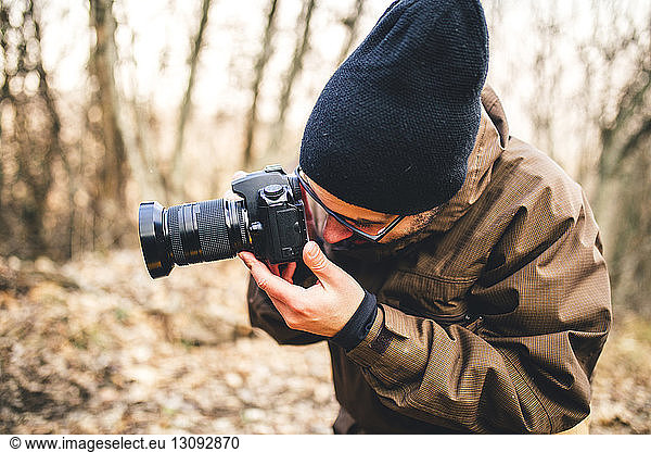 Male hiker photographing in forest