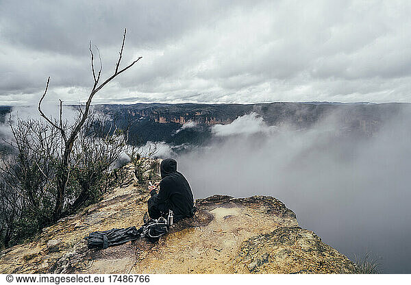Male hiker resting on remote hilltop  Australia