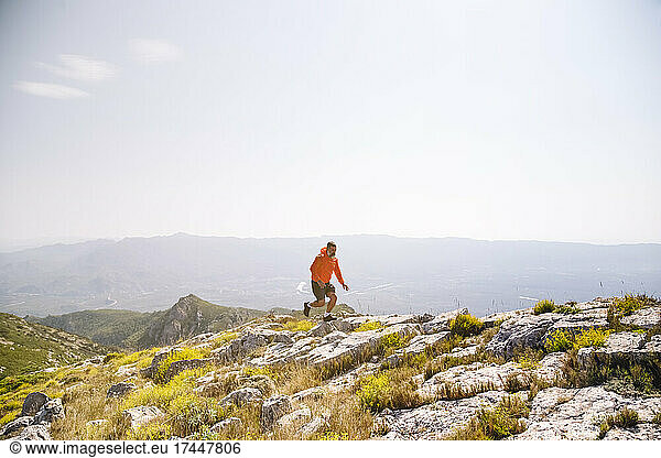 Male hiker running on rocks in mountain