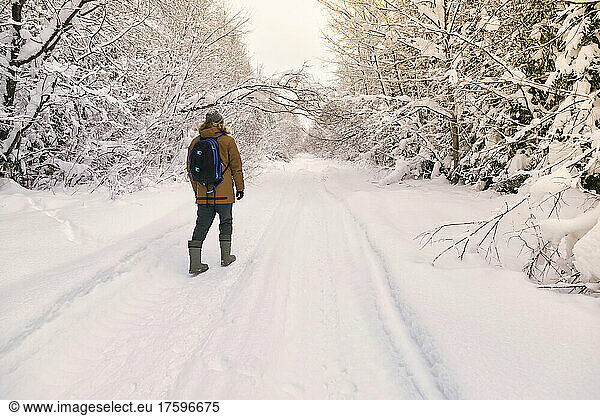 Male hiker walking in snow covered forest