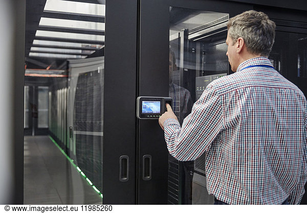 Male IT technician inputting security code at server room access door