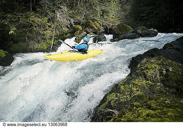 Male kayaker balancing at river