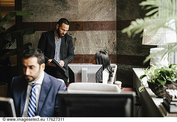 Male lawyer discussing with female colleague at law office
