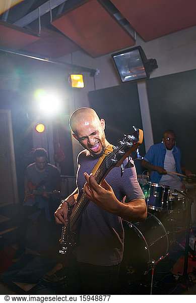 Male musician playing guitar in recording studio
