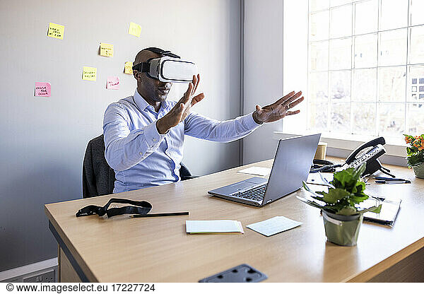 Male professional with Virtual reality headset at office