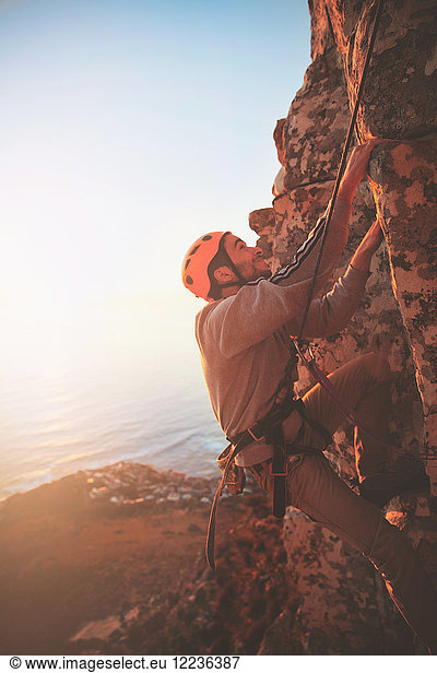 Male rock climber scaling rock