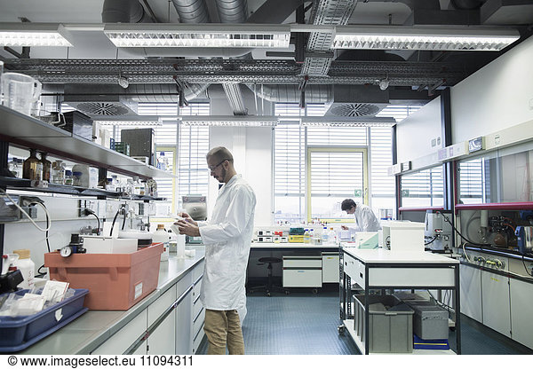Male scientists working in a pharmacy laboratory