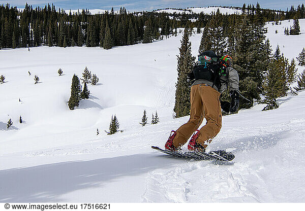 male Snowboarder riding snow in colorado backcountry